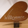 Edelrostherz auf Holzquadrat mit Aufschrift "Willkommen"